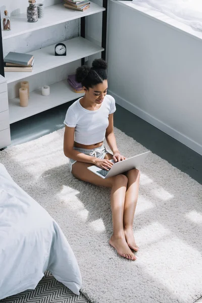 Vista Ángulo Alto Chica Afroamericana Usando Ordenador Portátil Blanco Sentado — Foto de stock gratuita