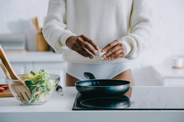 cropped shot of woman frying scrambled egg for breakfast at kitchen