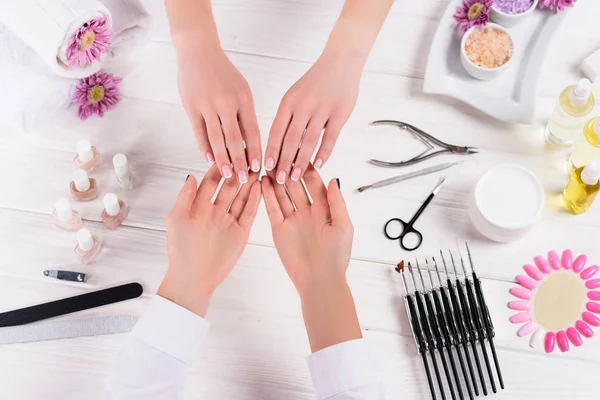 Gedeeltelijke Weergave Van Schoonheidsspecialiste Manicure Van Vrouw Aan Tafel Kijken — Stockfoto