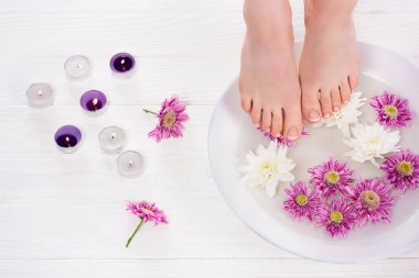 Kırpılan çekim yalınayak kadın banyo için çivi çiçek koku mum yakınındaki güzellik salonunda alma