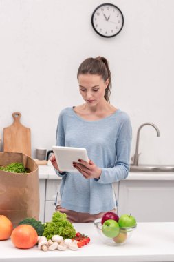 tablet satın sonra evde bakkal alışveriş listesi kontrol ile çekici yetişkin kadın