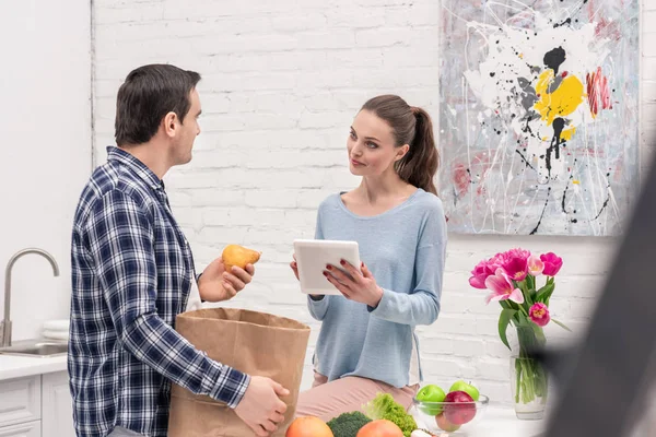 微笑的成人夫妇检查购买在平板电脑后购物清单 — 图库照片