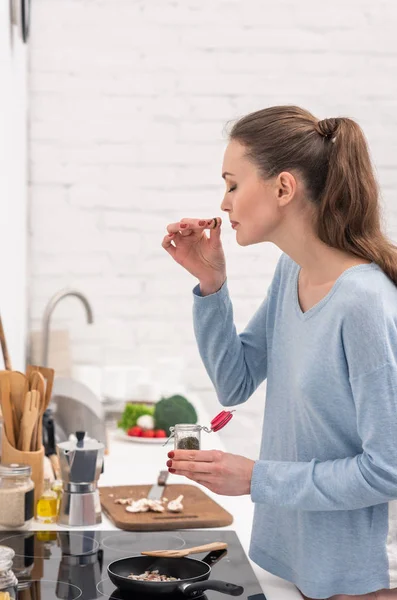 Bela Mulher Adulta Farejando Especiarias Sobre Alimentos Cozinhar Frigideira Cozinha — Fotografia de Stock