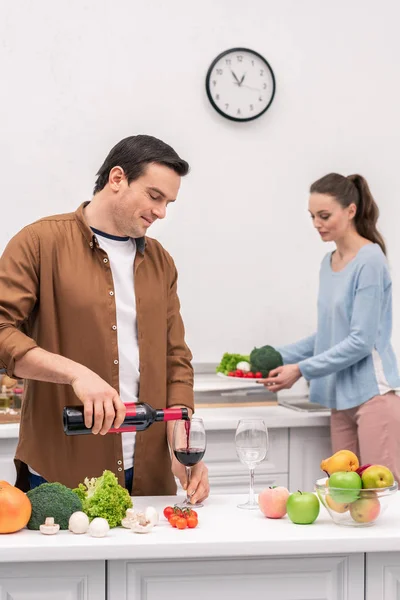 Happy Husband Pouring Wine Wife Dinner Preparation — Free Stock Photo