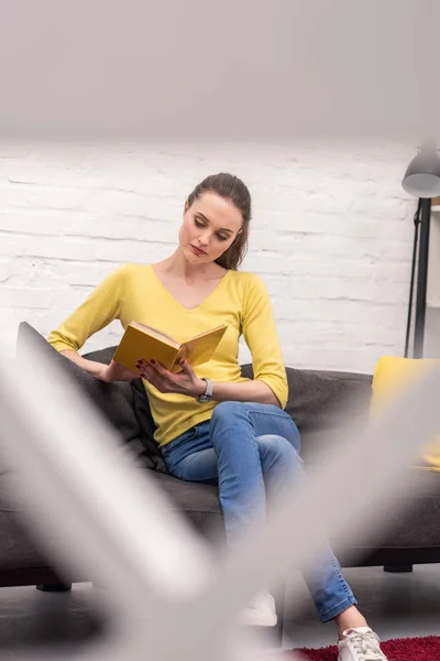 Attraente Donna Adulta Lettura Libro Sul Divano Casa — Foto stock gratuita