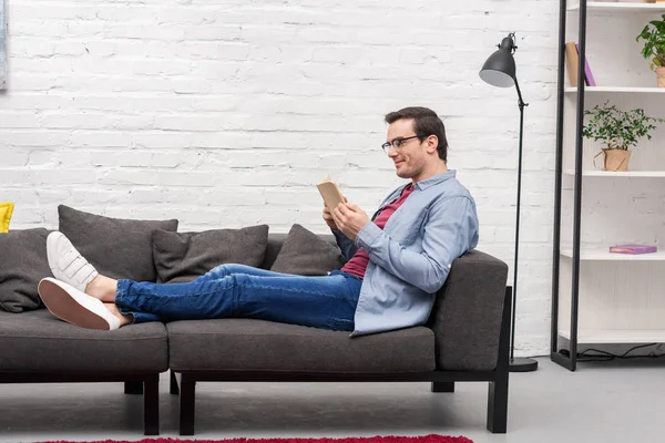 Side View Happy Adult Man Reading Book Couch Home — Stock Photo, Image