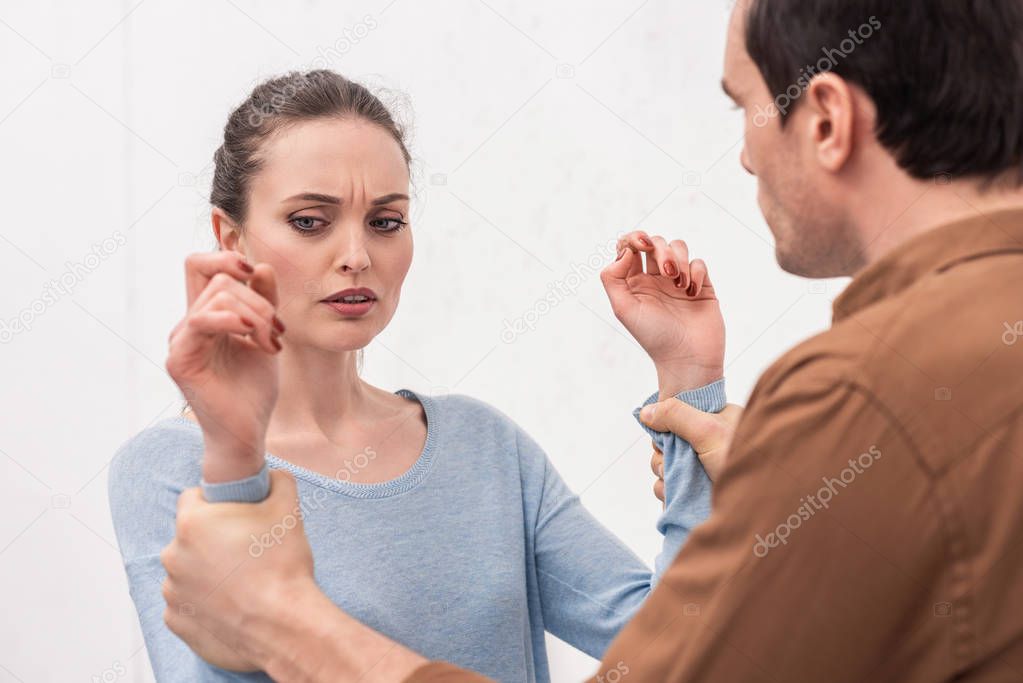 angry man holding hands of woman during argument