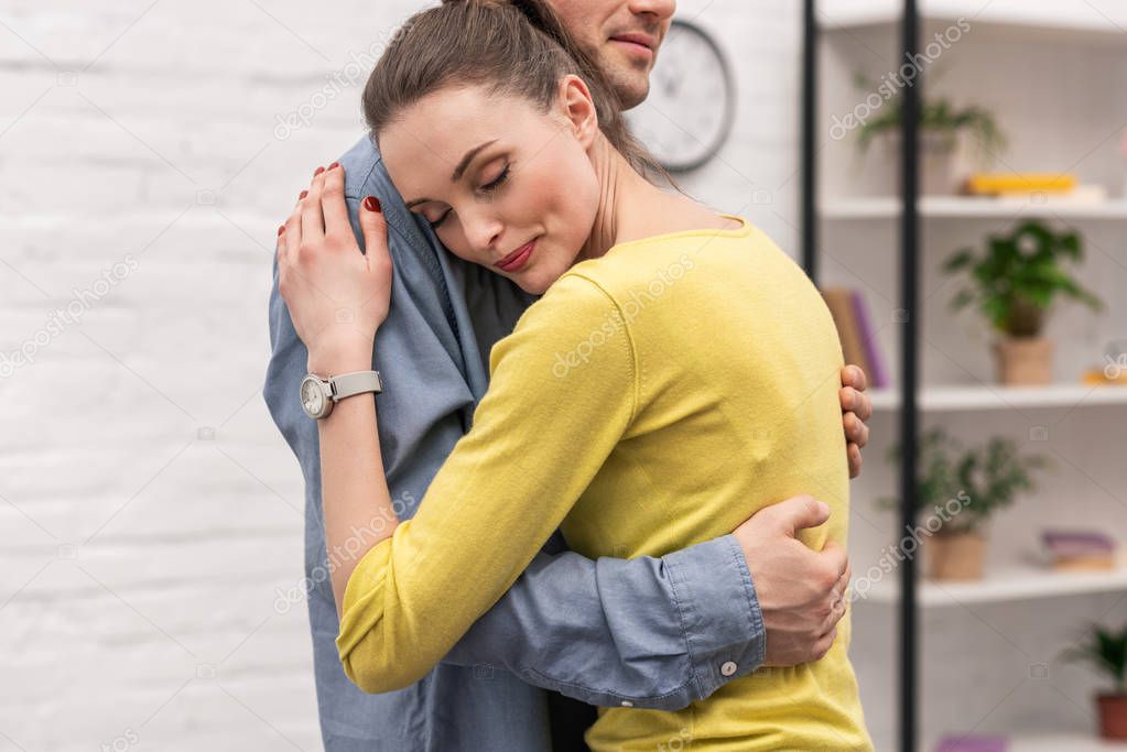 cropped shot of adult couple embracing at home