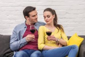 krásný dospělý pár s sklenice červeného vína spolu trávili čas doma