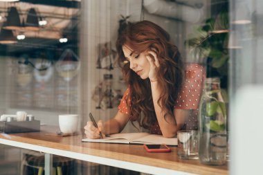 Genç blogger kafede kahve masasında Not defterinizdeki notlar yapma