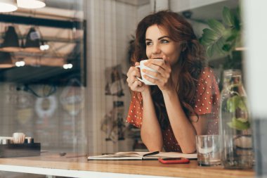 Kafede kahve içen genç bir kadının portresi.