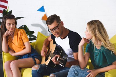 güzel gülümseyen kız yakışıklı genç adama akustik gitar çalmaya arıyorum