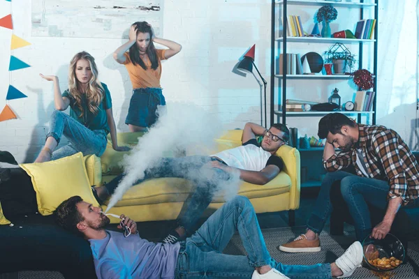 Young Man Lying Floor Smoking Electronic Cigarette While Partying Friends — Stock Photo, Image