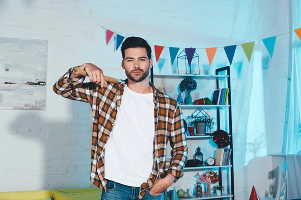 Handsome Young Man Holding Baseball Bat Looking Camera Home Party — Free Stock Photo