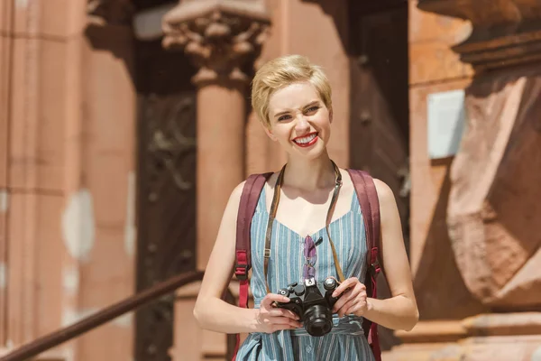 şehirde Kamera sırt çantası ve fotoğraf gülümseyen gezgin 