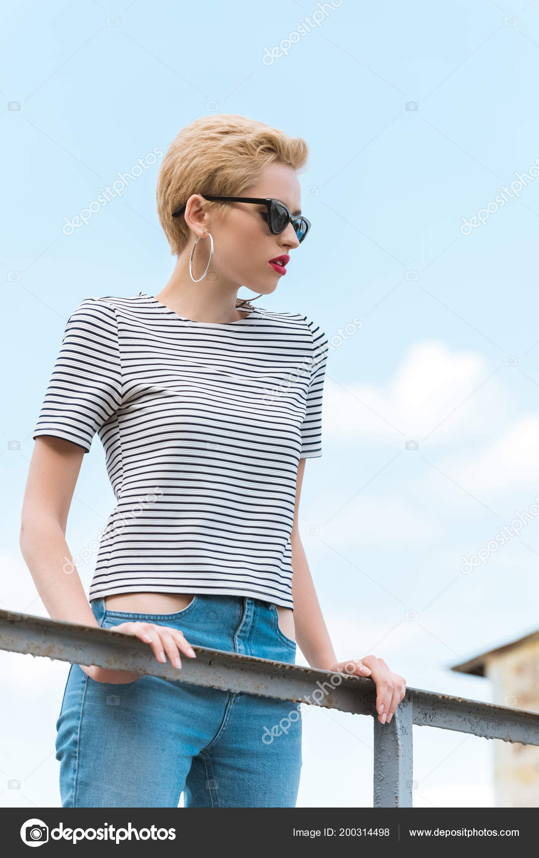 Tom boy Girl shows thumb down in stylish sunglasses with trend short hair.  Fashion summer look Stock Photo | Adobe Stock