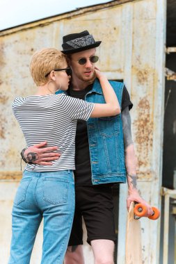 şık kız sarılmış dövmeli erkek kaykay ile