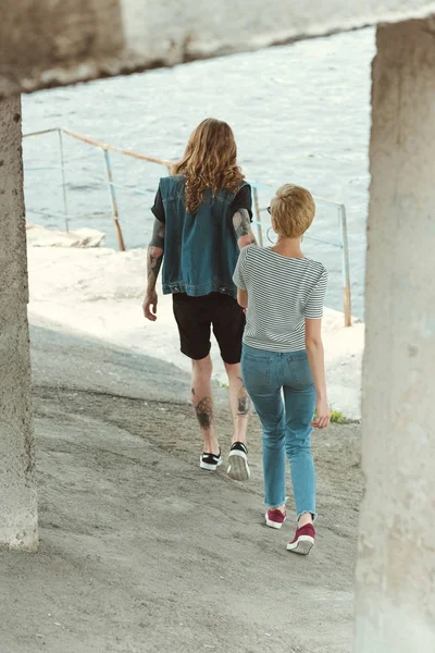 Widok Chłopaka Tatuażami Stylowe Dziewczyna Chodzenie Pod Most Nad Rzeką — Darmowe zdjęcie stockowe