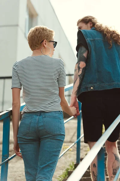 Back View Boyfriend Tattoos Stylish Girlfriend Holding Hands Walking Stairs — Free Stock Photo