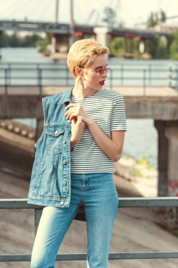 kot pantolon ve denim yelek köprüde duran ve uzağa arıyorsunuz şık kız
