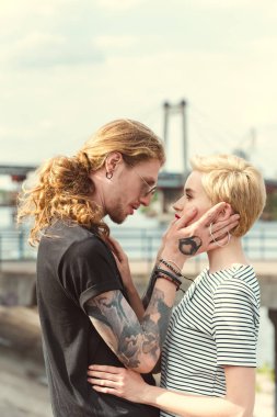 dövme ve birbirine köprüde bakarak şık kız ile erkek arkadaşı