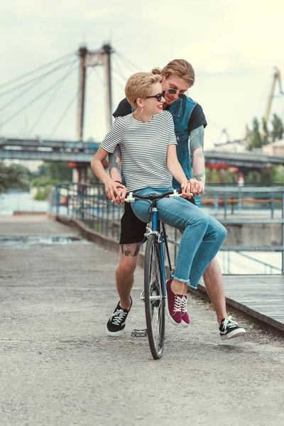 Freund Mit Tattoos Und Lächelnder Stilvoller Freundin Auf Fahrrad Auf — kostenloses Stockfoto