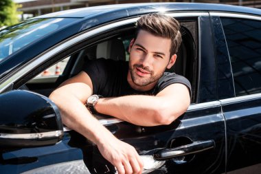 arabada oturan gülümseyen yakışıklı genç adam portresi 