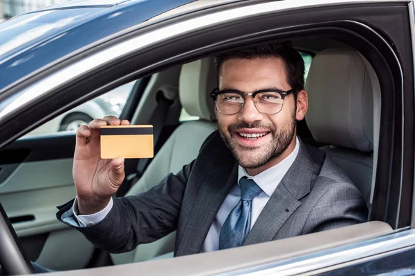 Retrato Homem Negócios Sorrindo Mostrando Cartão Crédito Mão Enquanto Sentado — Fotografia de Stock