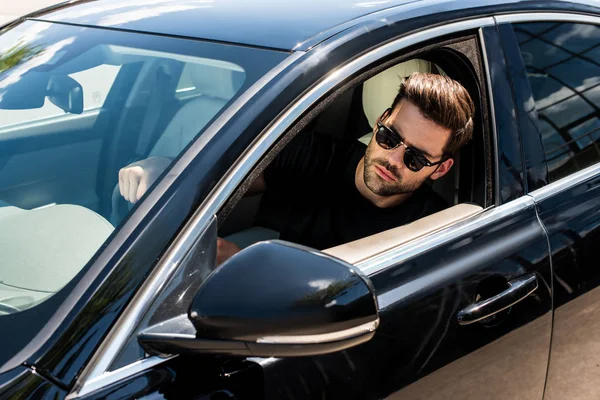 自信的年轻时尚的人在太阳镜驾驶他的车 — 图库照片