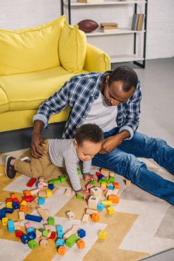bir genç baba evde renkli bloklarla oynama şirin küçük oğlu ile yüksek açılı görünüş