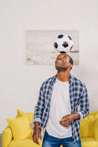 Sonriente Joven Afroamericano Hombre Balanceando Pelota Fútbol Cabeza Casa — Foto de Stock