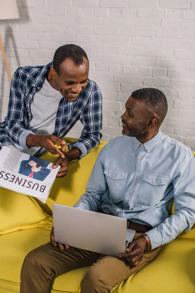 Sourire Jeune Homme Avec Journal Regardant Père Aîné Aide Ordinateur — Photo