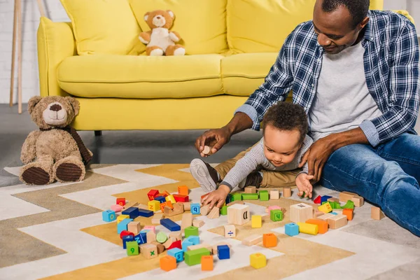 sevimli küçük oğluyla evde renkli bloklarla oynama genç baba