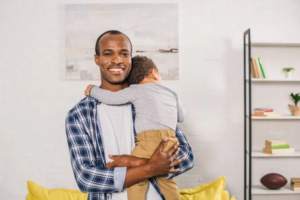 Feliz Jovem Afro Americano Pai Sorrindo Para Câmera Enquanto Carrega — Fotografia de Stock