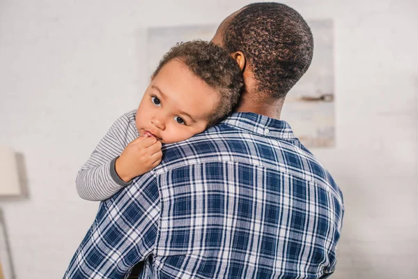 sevimli küçük oğlu evde taşıyan genç Afro-Amerikan baba
