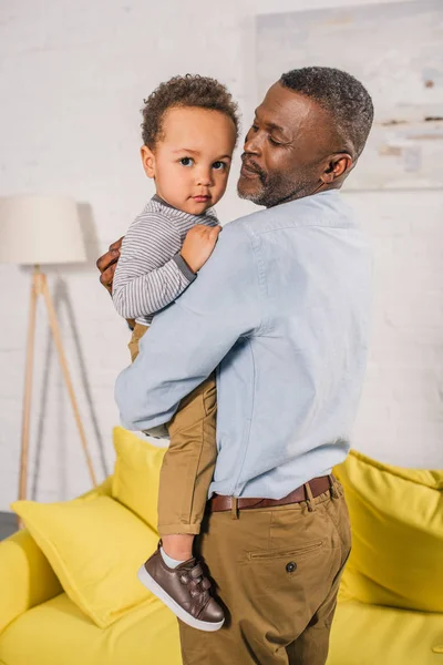 Glad Afroamerikanska Farfar Transporterar Bedårande Lilla Barnbarn Hemma — Stockfoto