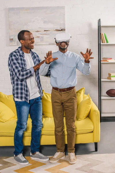 Smiling Young Man Looking Happy Elderly Father Using Virtual Reality — Stock Photo, Image