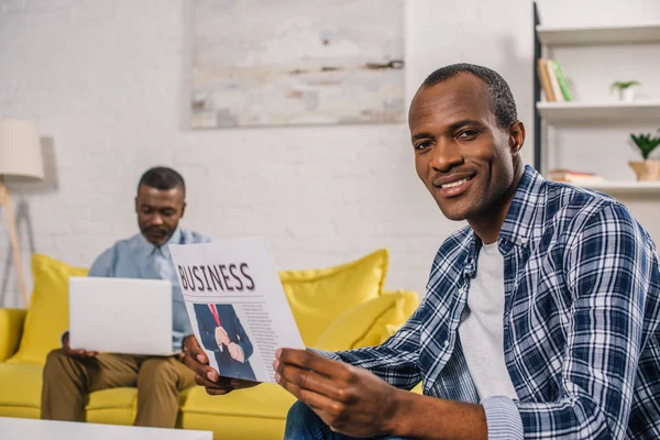 Jeune Homme Lisant Journal Affaires Souriant Caméra Tandis Que Père — Photo