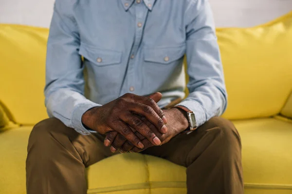 Beskuren Bild Senior Afroamerikanska Mannen Sitter Gula Soffan — Stockfoto
