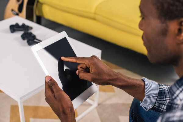 cropped shot of young african american man using digital tablet with blank screen