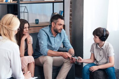 kadın avukat Pano smartphone Kulaklığımda oğlundan terapi seansı götürüp adam notlar alarak dikiz 