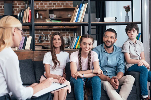 Familia Sonriente Sesión Terapia Por Una Consejera Escribiendo Portapapeles Oficina — Foto de Stock