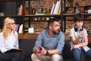 smartphone aile terapisi oturumda kullanma office boyun kulaklık oğluyla konuşurken adam kanepede oturan kadın avukat bey 