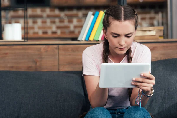 Koncentrovaná Dospívající Dívka Pomocí Digitálních Tabletu Zatímco Sedí Gauči Doma — Stock fotografie