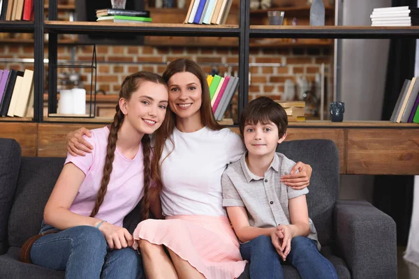 Sorrindo Mãe Abraçando Filha Adolescente Filho Pequeno Sofá Casa — Fotografia de Stock