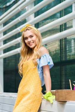 Lastik eldiven sera kameraya gülümseyen güzel genç kadın