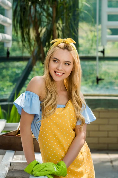 Lastik eldiven uzakta serada arıyorum güzel gülümseyen genç kadın