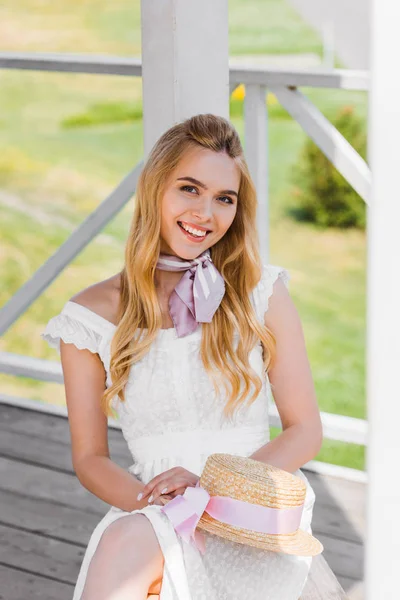 Beautiful Blonde Girl White Dress Holding Wicker Hat While Sitting — Stock Photo, Image