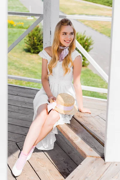 木製のベンチに座っていると 離れて見て白いドレスで美しい笑みを浮かべて少女のハイアングル — ストック写真