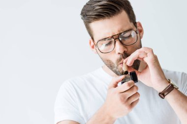 Beyaz arka plan üzerinde izole puro aydınlatma gözlük yakışıklı sakallı adam